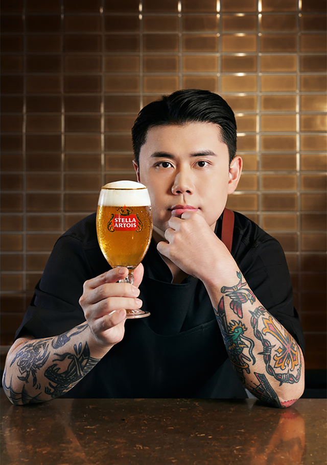 스텔라 아르투아 x 권성준 셰프의 만남 권성동 쉐프가 스텔라 아르투아 생맥주가 가득찬 전용잔인 챌리스 잔을 들고 카메라를 응시하고 있습니다