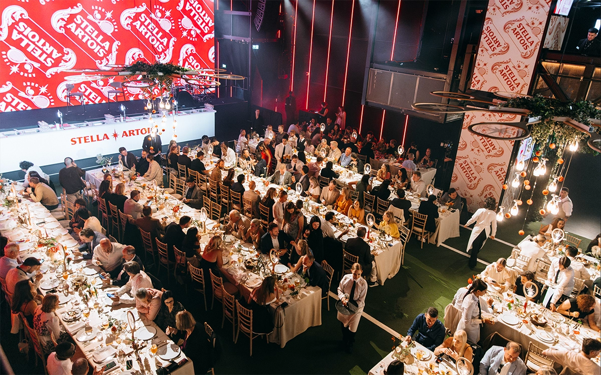스텔라 아르투아 '2025 퍼펙트 서브 어워즈' 현장 사진 스텔라 아르투아 2025 퍼펙트 서브 어워즈 현장으로 긴테이블에서 생맥주를 즐기는 사람들이 있습니다.
